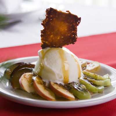 Mix de frutas flambeadas con helado de americana sobre crema de almendras