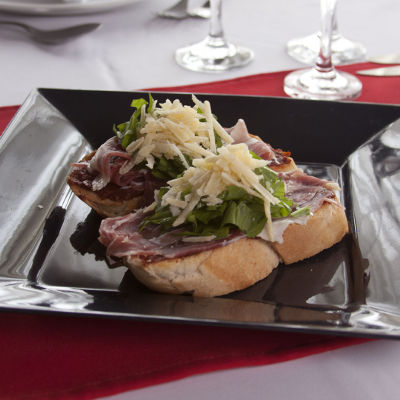 Tostón con jamón serrado, rúcula y parmesano